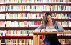 books, girl in library reading book