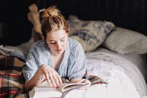 girl on bed reading book, relaxing